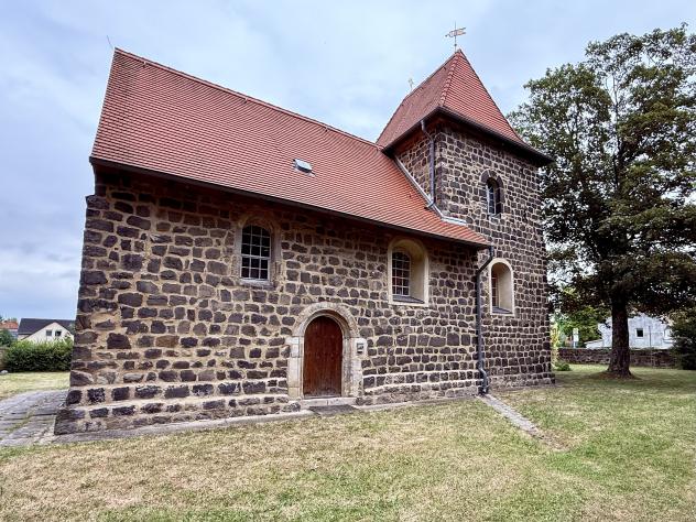 Die älteste Wehrkirche Sachsens (um 1200) mit rustikalem Mauerwerk und nun wieder begehbarem, von Schwertern gezeichnetem Südportal.