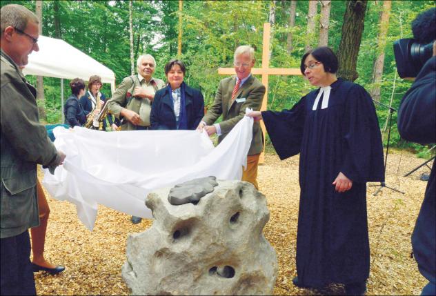 Zur Eröffnung des »Friedwald Planitzwald« enthüllen Bürgermeister Bernd Laqua (l.), Hans-Adam von Schultzendorff (2. v. r.) und Pfarrerin Barbara Lötzsch einen Stein mit einem großen Eichenblatt.