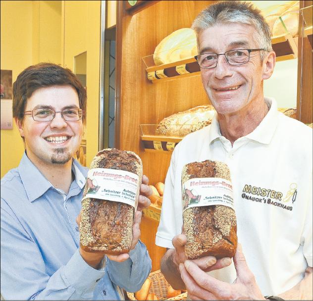 Für eine neue Heizung in der Kirche Sebnitz sammeln Pfarrer Lothar Gulbins und Bäcker Lutz Gnauck Geld mit dem »Heizungsbrot«.   