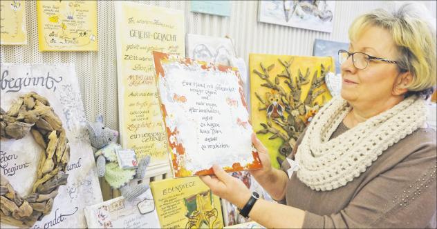 Künstlerin mit Worten: Rosmarie Keller zeigt auf der christlichen Kreativmesse in Thalheim verschiedene Schrifttafeln mit Sinnsprüchen. Dabei mussten die Kunstwerke nicht unbedingt den christlichen Glauben zum Inhalt haben. Foto: C. Zehrfeld 