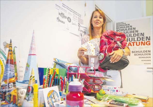 Gespendet: Katja Beyer von der Kirchlichen Erwerbsloseninitiative Leipzig vor dem Tisch, an dem sich bedürftige Familien Materialien für die Schule mitnehmen dürfen. In der Hand hält sie eine besondere Spende aus Koblenz. Foto: Jan Adler