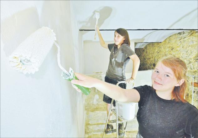 Junge Gemeinde einmal anders: Emilia (hinten) und Jasmin schwingen im ehemaligen Schweinestall die Pinsel, der künftig unter anderem die sanitären Anlagen aufnehmen wird. Foto: R. Dietze Workcamp, Polenz, Bauernhof, Junge Gemeinde, Machern