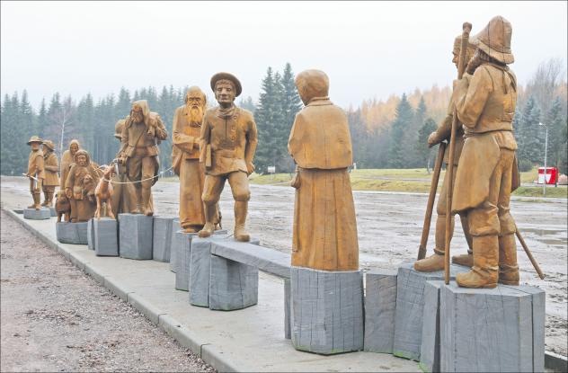 Denkmal: Vertrieben von den Katholiken (l.) flüchten die evangelischen Gläubigen aus Böhmen über die Grenze nach Sachsen (Figurengruppe Mitte) und werden am Fastenberg in Oberjugel von den dortigen Bewohnern aufgenommen (r.). Foto: Irmela Hennig Johanngeorgenstadt, Exulanten, Holzfiguren
