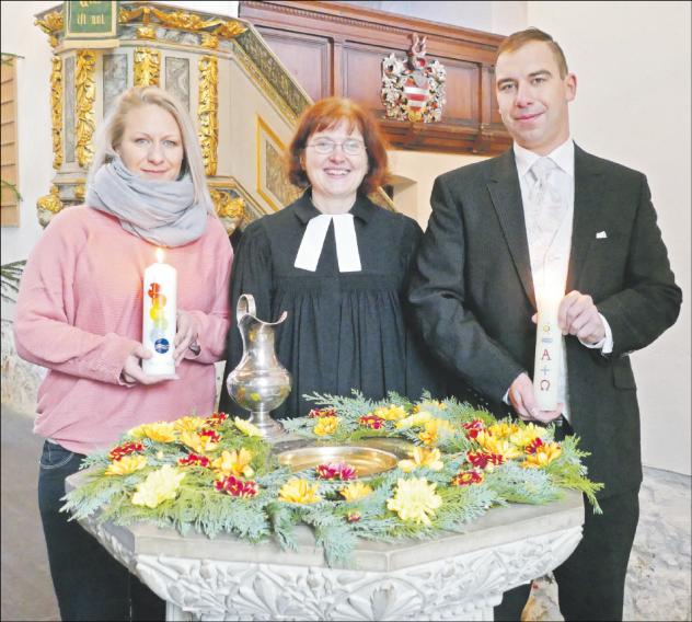 Glücklich getauft: Die Mitarbeitern der Diakonie Leipziger Land Susan Naundorf und Steve Nowotsch am Taufstein mit der Otterwischer Pfarrerin Susann Donner. Foto: Diakonie Leipziger Land Taufe, Taufkerze, Taufstein, Kirche Otterwisch, Pfarrerin Susann Donner