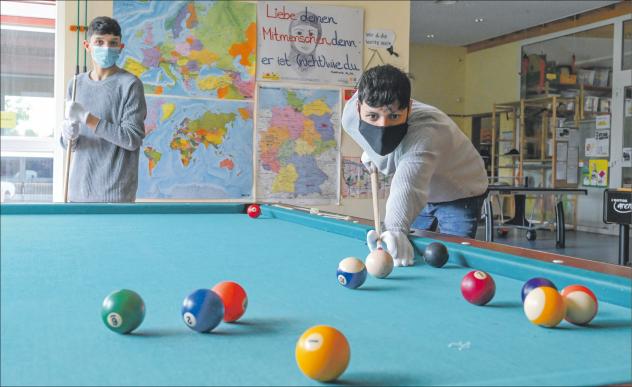 Gemeinsame Freizeit: Shaheen (l.) und Amao dürfen im CVJM-Jugendhaus »Chilli« auch wieder Billard spielen mit weißen Handschuhen. Beim Spiel müssen sie eine Queue-Länge Abstand halten. Foto: Steffen Giersch Jugendhaus, Billard, Chilli, Dresden, CVJM, Jugendliche, Freizeittreff