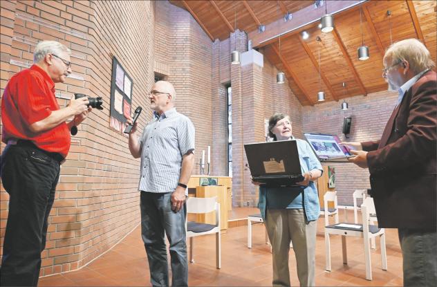 Sie bringen die Kirche ins Internet (v. l.): Michael Schied filmt Pfarrer Thomas Böttrich, während Elisabeth und Gottfried Schlemmer das Ergebnis im Internet bestaunen. Am Tag des offenen Denkmals ist der Rundgang im Netz. Foto: Steffen Giersch Denkmal, Kirche, digital, Film, Gemeindezentrum, Dresden,