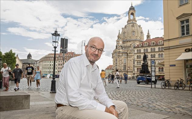 Mehr Kirche für die Gesellschaft: Landesbischof Tobias Bilz sitzt auf dem Neumarkt in Dresden mit der Frauenkirche im Hintergrund. Der leitende Geistliche möchte einige Veränderungen in der Landeskirche anstoßen