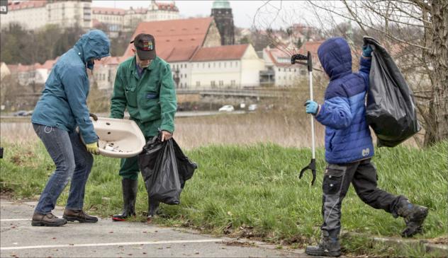 Ulrike Lahl mit Sohn aus Graupa und Burkhard Huth aus Pirna gehörten zu den Helfern der Kirchgemeinde, die in Pirna-Copitz Müll beseitigten.