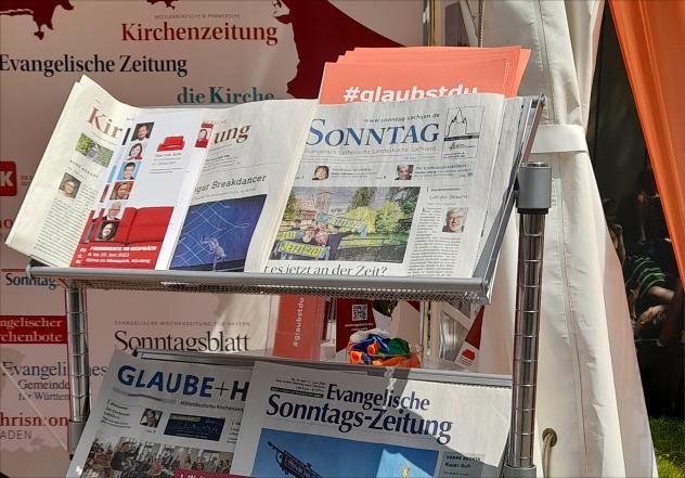 DER SONNTAG mit anderen evangelischen Wochenzeitungen Deutschlands am Stand des Evangelischen Presseverbandes auf dem Kirchentag in Nürnberg.