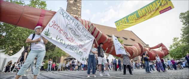 Mit einem meterlangen Regenwurm haben Bauern im Juni beim Kirchentag in Nürnberg die Kirche zu einer sozialen und ökologischen Landvergabe aufgefordert.