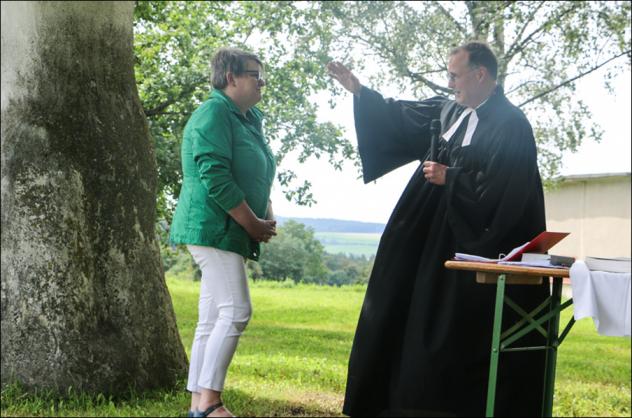 Gottesdienst im Grünen auf der Stelzenhöhe: Pfarrer Gero Erber segnet Anja Hanke. © Simone Zeh