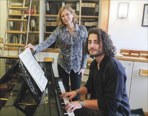 Kirchenmusik im Blick: Elke Voigt, Kantorin im Kirchspiel Dresden-Neustadt, mit  Carl Landgraf, der ein Freiwilliges Soziales Jahr absolviert, am Flügel in der Notenbibliothek des Kirchspiels Dresden. © Tomas Gärtner