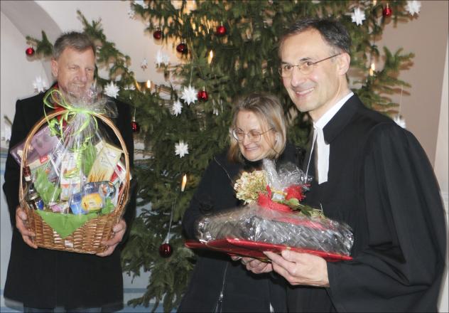 Abschied in der Schlosskirche Mühltroff: Gert Dreyhaupt und Sandy Behr vom Kirchenvorstand überbringen im Festgottesdienst Geschenke anlässlich der Verabschiedung von Pfarrer Rainer Sörgel (r.).Foto: Simone Zeh 