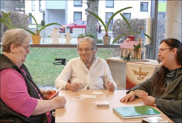 Ehrenamtliche Helferin Maria Heinzig beim Kartenspielen mit Bewohnerinnen im Heimverbund Leipziger Land gemeinnützige GmbH. Foto: Diakonie Leipziger Land