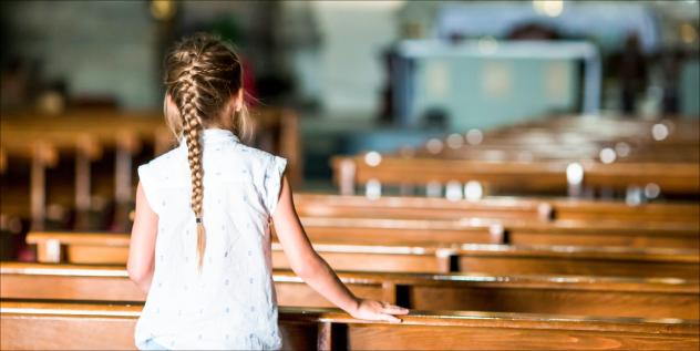 Ein Kind in der Kirche zwischen Kirchenbänken (Symbolfoto). Foto: travnikovstudio – stock.adobe.com Kinder Glauben