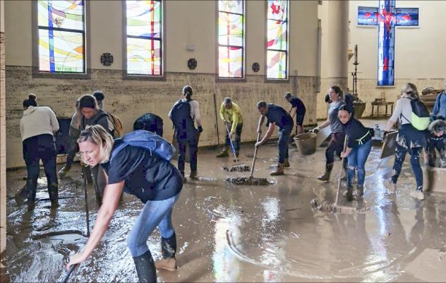Unermüdlich: Freiwillige Helfer säubern die Pfarrkirche von Paiporta nach der Überschwemmung. Auch die Christus-Figur (kleines Foto) hat die Flut nicht unbeschadet überstanden. © Salvador Romero; Arzobispado de Valencia
