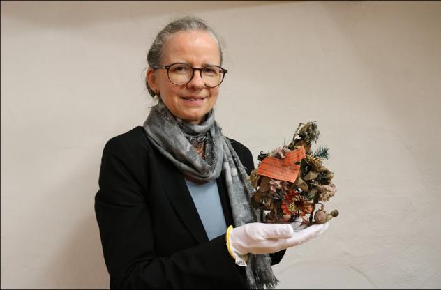 Sylke Kaufmann zeigt eine der Kamenzer Totenkronen, die im Stadtgeschichtlichen Museum aufbewahrt werden. © Irmela Hennig