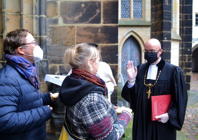 Nach dem Gottesdienst am Reformationstag verteilte Landesbischof Tobias Bilz Reformationsbrötchen am Ausgang für die Gottesdienstbesucher- wegen der Coronabestimmungen mit Handschuhen und Schutzmaske. Foto: K. König Tobias Bilz, Landesbischof, Corona, Maske, Meißen, Dom, Gottesdienst, Reformationsbrötchen