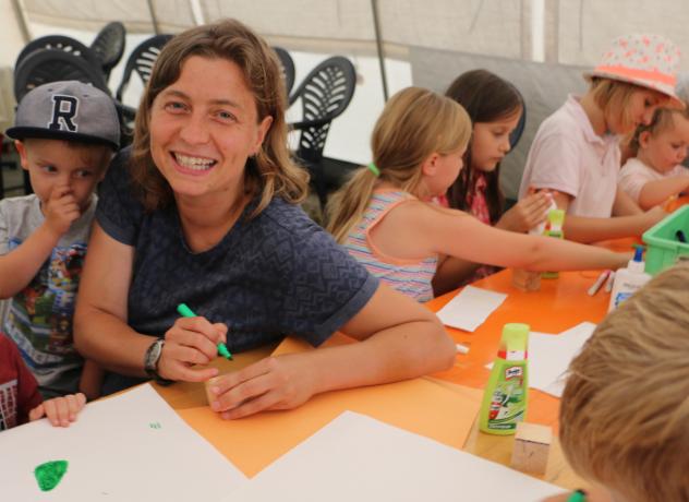 Katja Roßbach bemalt mit den Kindern bei »Kirche unterwegs« an der Talsperre Pirk sogenannte Gebetswürfel aus Holz. Foto: Simone Zeh Kirche unterwegs, Katja Roßbach, Vogtland, Talsperre, Zeltplatz, Pirk, Pöhl