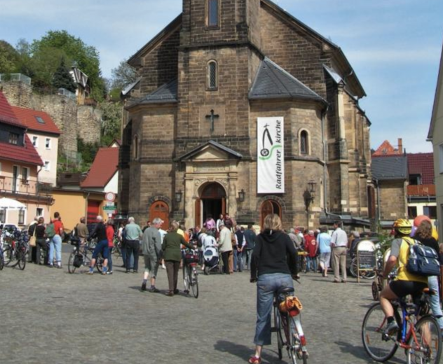 Radfahrer vor der Kirche in Stadt Wehlen am Elberadweg in der Sächsischen Schweiz. 