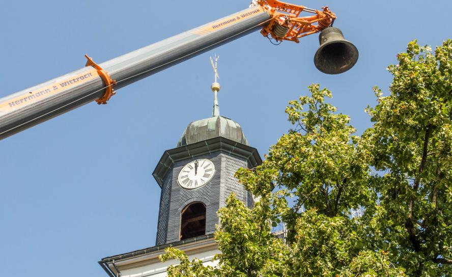 Ein großer Kran hat zwei Glocken aus dem Kirchturm in Zöblitz gehoben. Nun können sie repariert werden. © Jan Görner