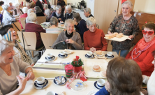 Ältere Frauen und Männer in frohem Austausch bei Pfannkuchen und Kaffee. Der Nachmittag zu Rosenmontag gehörte zum Programm des »Netzwerks 60+« in Dresden. © Tomas Gärtner