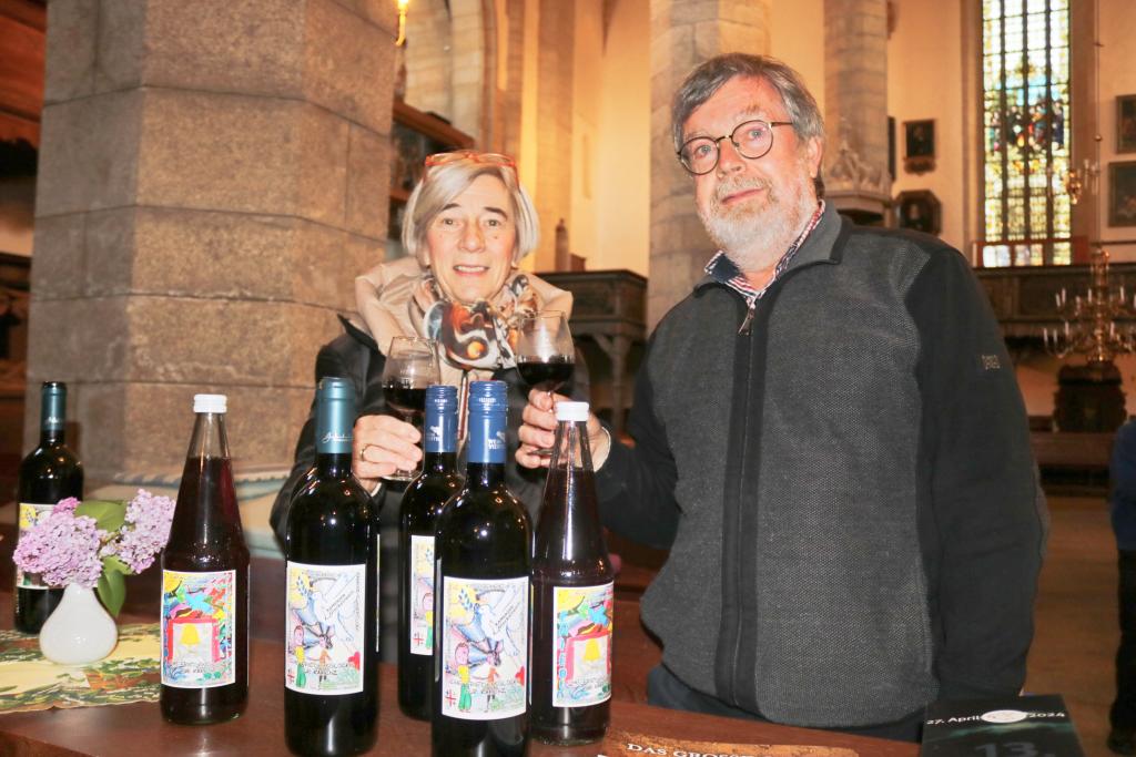 Elfie Jatzke und Thomas Hein vom Kirchenvorstand präsentieren den Glockenwein zugunsten einer Friedensglocke. © Irmela Hennig