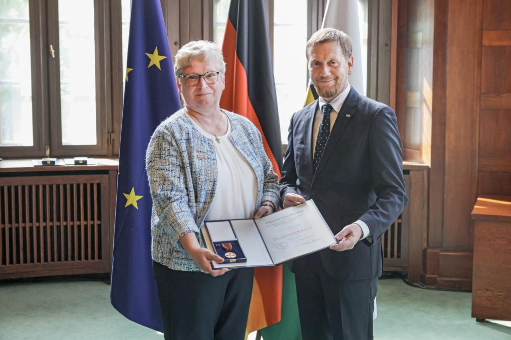 Christiane Scheurer bekommt von Ministerpräsident Michael Kretschmer den Orden am Band überreicht. Fotos: Dirk Sukow