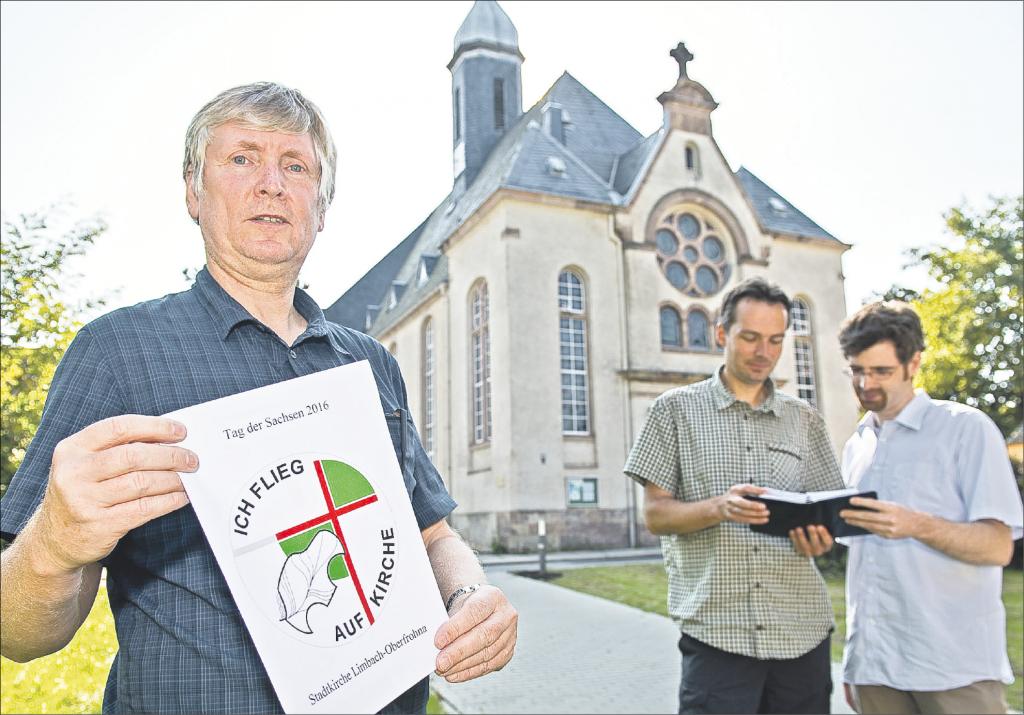 Pfarrer Andreas Vögler (l.) zeigt das Motto zum Tag der Sachsen in Limbach-Oberfrohna. Zusammen mit Kantor Jürgen Baldauf (r.) und Gemeindepädagoge Tommy Barthold ist vom 2. bis 4. September alles vorbereitet. Foto: Dostmann