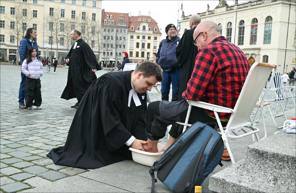 Pfarrer Tobias Sommer wäscht Marek Drong aus Stuttgart am Gründonnerstag die Füße am Fuße des Lutherdenkmals vor der Dresdner Frauenkirche (weitere Fotos unter www.sonntag-sachsen.de). © Steffen Giersch