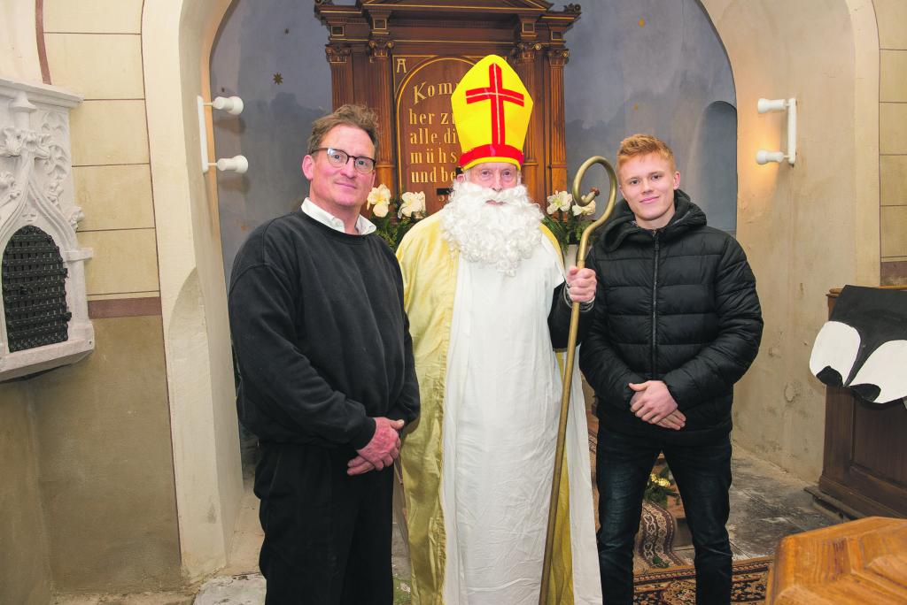 Nikolaikirche Zöschau v.l.n.r.: Joachim Zehme, Berthold Zehme als Nikolaus, Enkel Felix-Florian am 06.12.2022 bei einem festlichen Gottesdienst, wo die Ankunft des Heiligen Nikolaus dargestellt wurde. © Thomas Barth