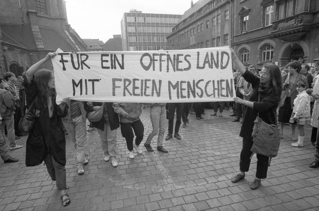 Am 4. September 1989 entrollten Gesine Oltmanns (l.) und Katrin Hattenhauer (r.) nach dem Friedensgebet ein Transparent. © Archiv Bürgerbewegung Leipzig/Armin Wiech_Foto015-006-146