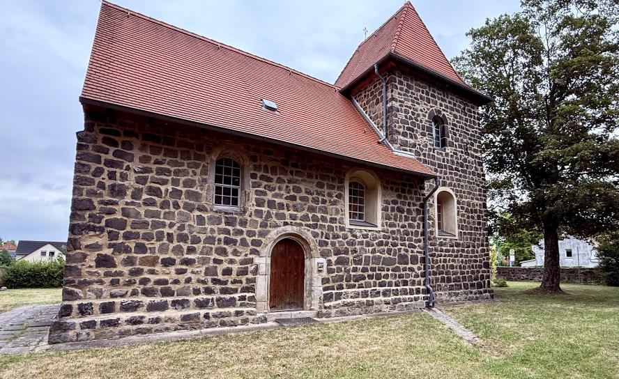 Die älteste Wehrkirche Sachsens (um 1200) mit rustikalem Mauerwerk und nun wieder begehbarem, von Schwertern gezeichnetem Südportal.