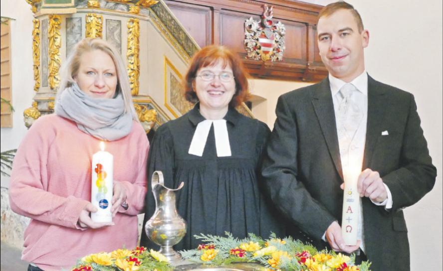 Glücklich getauft: Die Mitarbeitern der Diakonie Leipziger Land Susan Naundorf und Steve Nowotsch am Taufstein mit der Otterwischer Pfarrerin Susann Donner. Foto: Diakonie Leipziger Land Taufe, Taufkerze, Taufstein, Kirche Otterwisch, Pfarrerin Susann Donner