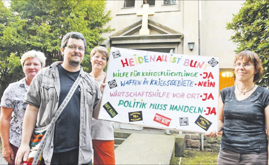 Für eine andere Botschaft: Heidenauer Christen im August 2015 nach einem Gottesdienst vor der Christuskirche Heidenau in Reaktion auf die rechtsextremen Demonstrationen der Vortage. Foto: Steffen Giersch Heidenau, Kirche, Plakat, Flüchtlingshilfe, Versöhnung