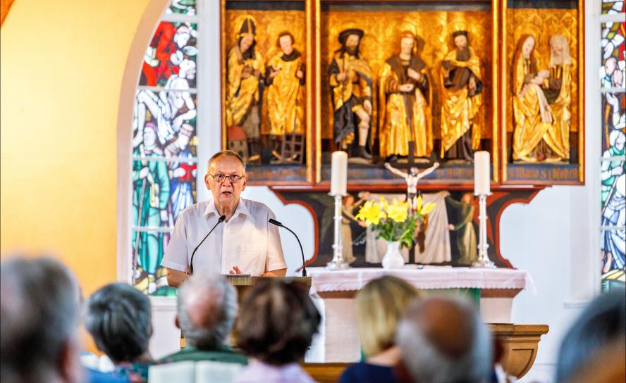 Andacht mit Altar: Kirchenvorstands-Vorsitzender Michael Pahle erinnert beim Kirchweihfest am 10. August an die Bedeutung des Altars – er zeigt unter anderem Pestheilige. © Uwe Winkler