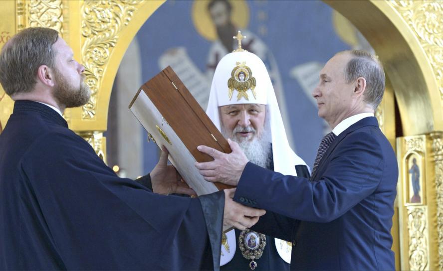 Nähe von Staat und Kirche: Patriarch Kyrill von Moskau (hinten) lässt Präsident Putin (r.) eine Ikone des Hl. Wladimir überreichen (2015). Foto: Chyornyy chelovek/CC BY-SA 4.0