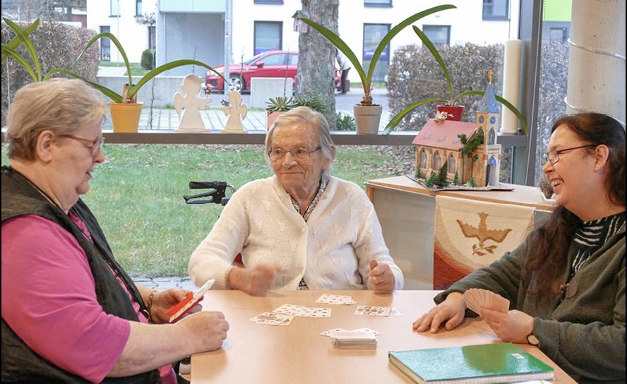 Ehrenamtliche Helferin Maria Heinzig beim Kartenspielen mit Bewohnerinnen im Heimverbund Leipziger Land gemeinnützige GmbH. Foto: Diakonie Leipziger Land