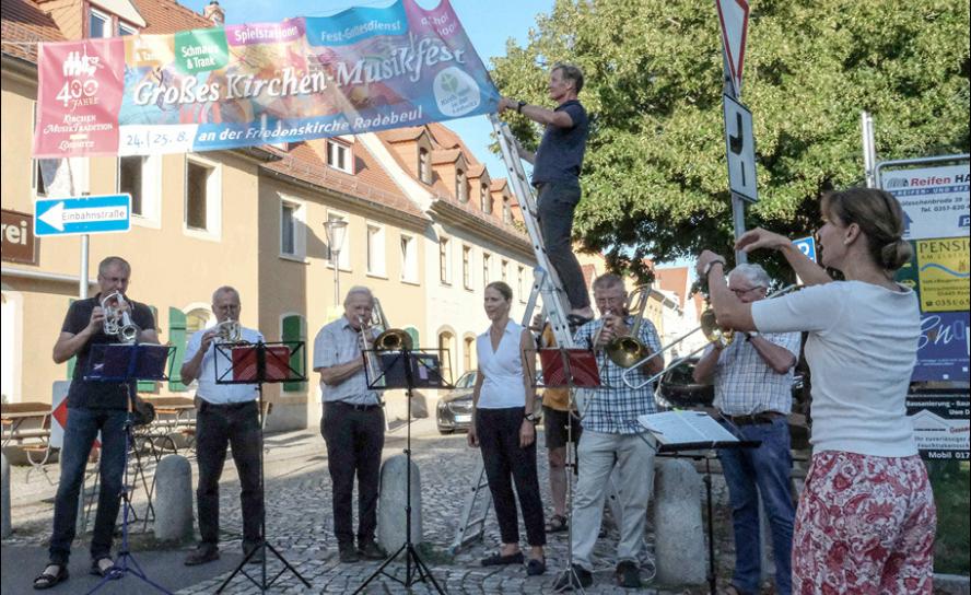 Zu den Klängen des Posaunenchors entfaltete Ingolf Miersch am Montag das große Banner auf dem Anger in Radebeul-Kötzschenbroda. © Birgit Andert