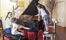 Mit der Künstlerin und Musiklehrerin Claudia Forberger (links) haben die Kinder verschiedene Instrumente ausprobiert. Der Flügel und Schlaginstrumente hatten es ihnen besonders angetan. © Julia Gerlach
