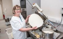 Carola Schmiedt in der Hostienbäckerei: Sie stellt Hostien aus dickflüssigem Teig aus Weizenmehl und Wasser her. Raumhohe Scheiben und eine Tür aus Glas trennen den Verkaufsraum von der Bäckerei. © Dietrich Flechtner Carola Schmiedt in der Hostienbäckerei: Sie stellt Hostien aus dickflüssigem Teig aus Weizenmehl und Wasser her. Raumhohe Scheiben und eine Tür aus Glas trennen den Verkaufsraum von der Bäckerei. © Dietrich Flechtner